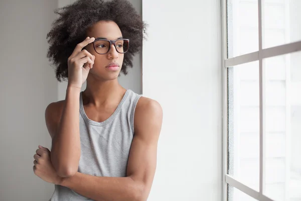 Alegre adolescente africano ajustando sus gafas — Foto de Stock