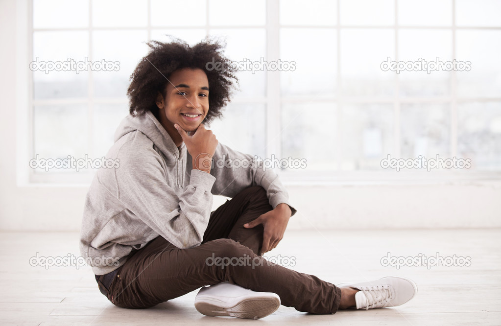 Teenage African boy sitting on the floor