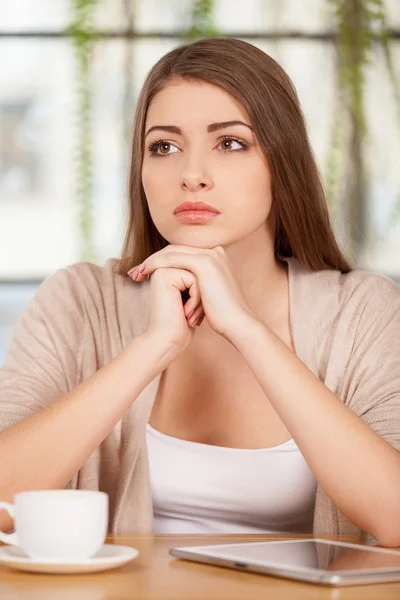 Frustrierte junge Frau sitzt im Restaurant — Stockfoto