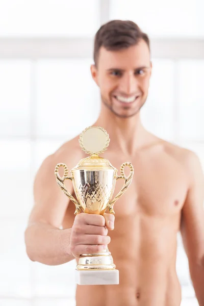 Мускулистый человек с золотым трофеем — стоковое фото