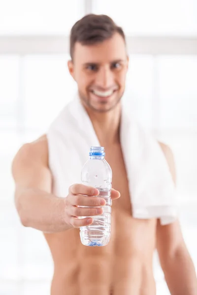 Muscular man holding a bottle — Stock Photo, Image