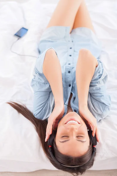 Lyssna på musik i sängen. — Stockfoto