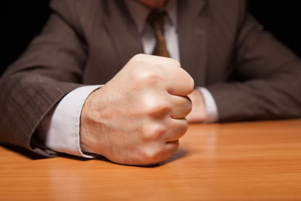 Homem de roupa formal segurando punho na mesa — Fotografia de Stock