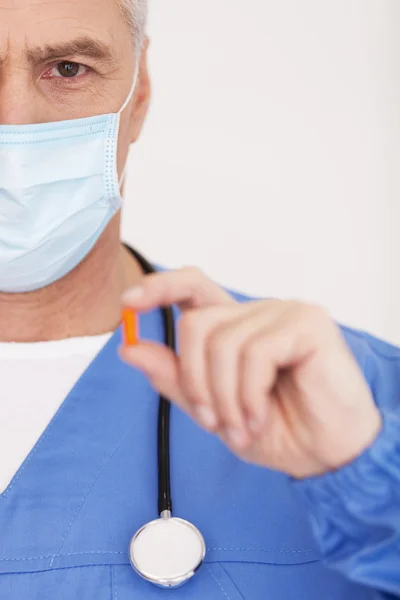 Doctor in de chirurgische masker weergegeven: een pil — Stockfoto