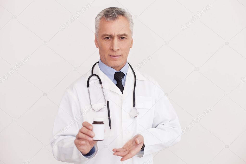 Doctor in uniform pointing a medicine bottle