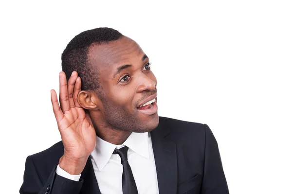 Fröhlicher junger afrikanischer Mann hält Hand ans Ohr — Stockfoto