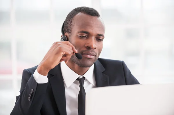 Afrikaanse man die op laptop — Stockfoto