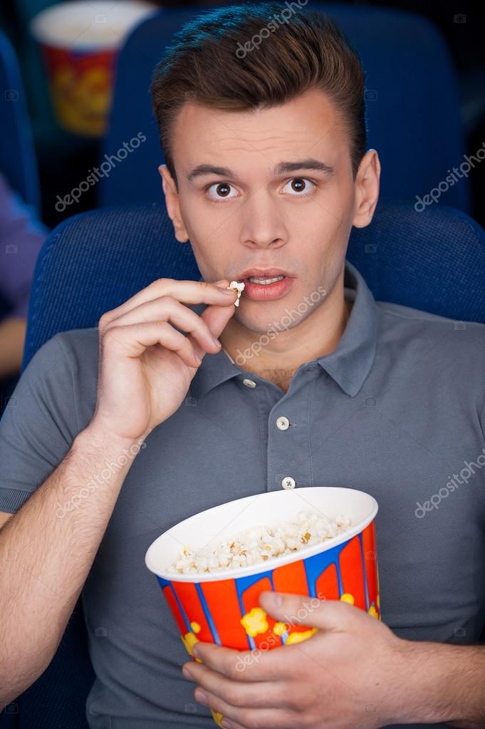 Man eating popcorn at the cinema — Stock Photo © gstockstudio ...
