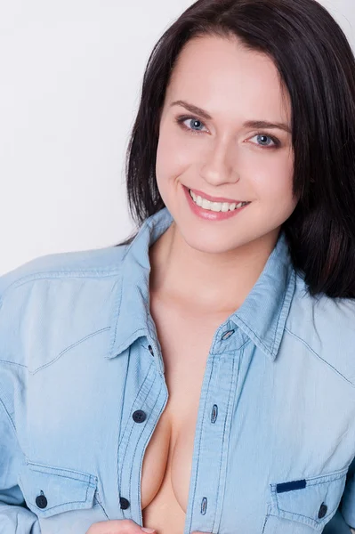 Young woman taking off blue shirt — Stock Photo, Image