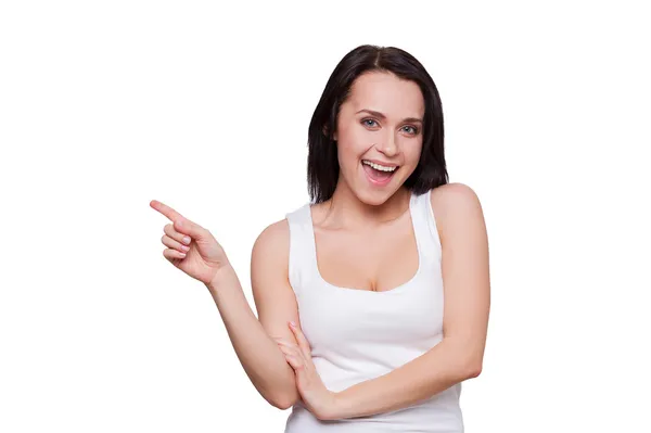 Kvinna med vackra klyvning pekar bort och ler — Stockfoto