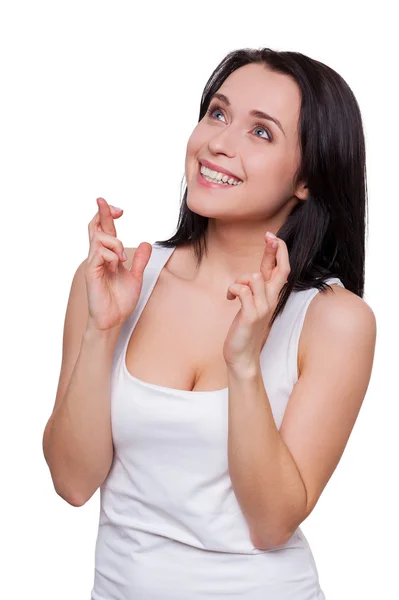 Woman looking away and keeping fingers crossed — Stock Photo, Image