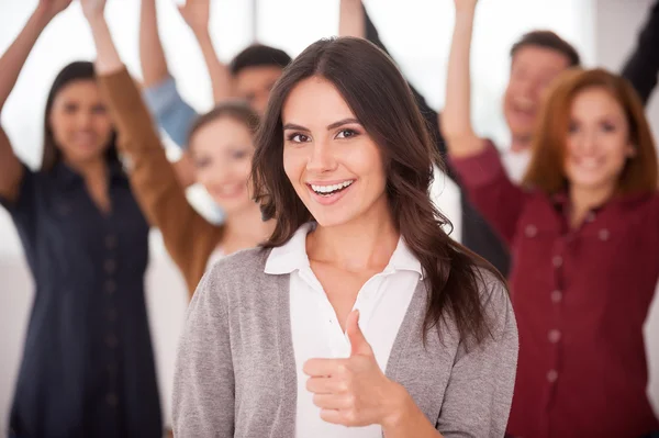 Hermosa joven mostrando su pulgar hacia arriba y sonriendo — Foto de Stock