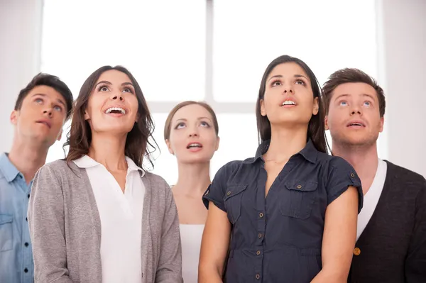 Gruppo di giovani che alzano lo sguardo in piedi uno vicino all'altro — Foto Stock