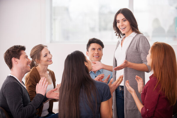 Woman telling something and gesturing for group of people