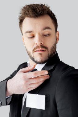 adam omzunun üzerinden bir şey kapalı sallayarak resmi kıyafeti