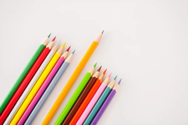 Top view of one simple pencil laying between multi colored pencils — Stock Photo, Image