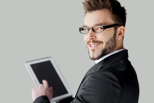 Man working on digital tablet and looking over shoulder — Stock Photo, Image