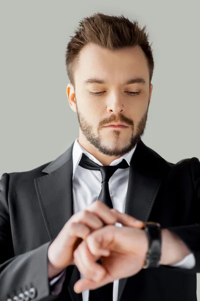 Junger Mann in Formalbekleidung kontrolliert die Uhrzeit — Stockfoto