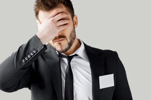 Hombre joven frustrado en formalwear cubriendo la cara con la mano —  Fotos de Stock