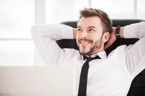 Homme barbu souriant tout en étant assis à son lieu de travail — Photo