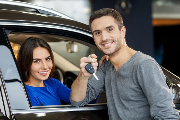 Handsome men standing near the car while his girlfriend sitting at the front seat — Stock Photo, Image