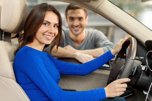 Couple are examining a new car at the dealership — Stock Photo, Image