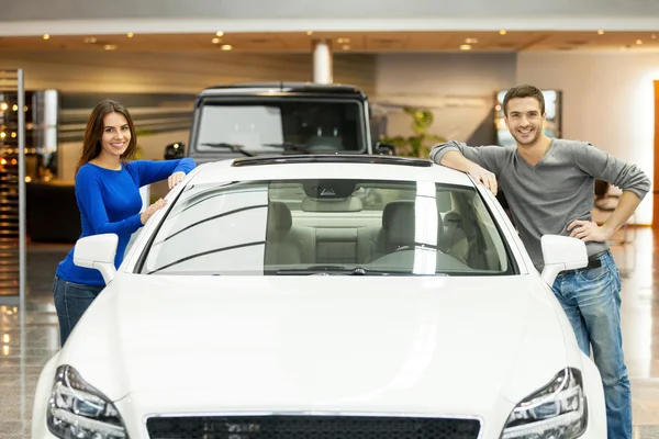 Couple debout des deux côtés de la voiture souriant à la caméra — Photo