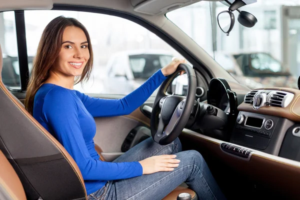 Žena sedí na předním sedadle automobilu, při pohledu na fotoaparát — Stock fotografie