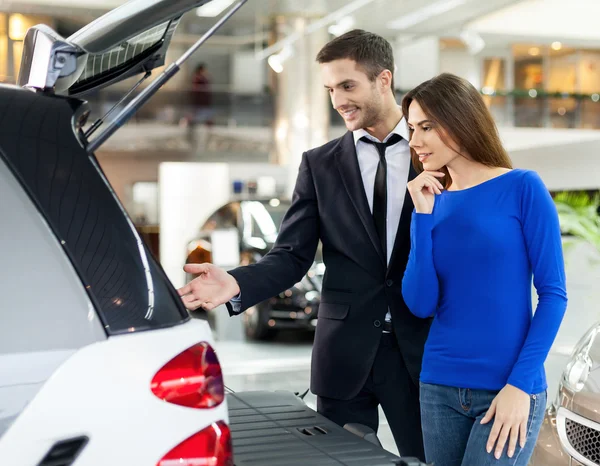Bilförsäljare som visar bilen stammen till kunden — Stockfoto
