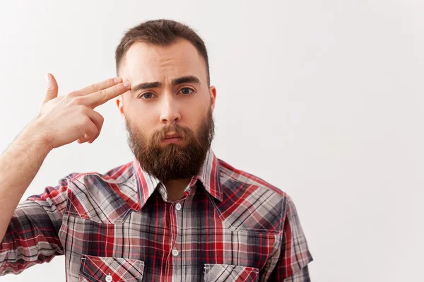 Depressiver junger Mann in Freizeitkleidung berührt mit Fingergewehr seine Schläfe — Stockfoto