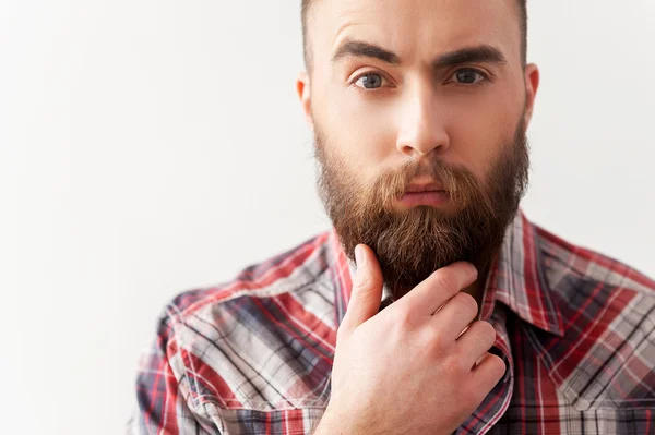 Portrait of handsome bearded young man with hand on chin — Stock Photo, Image