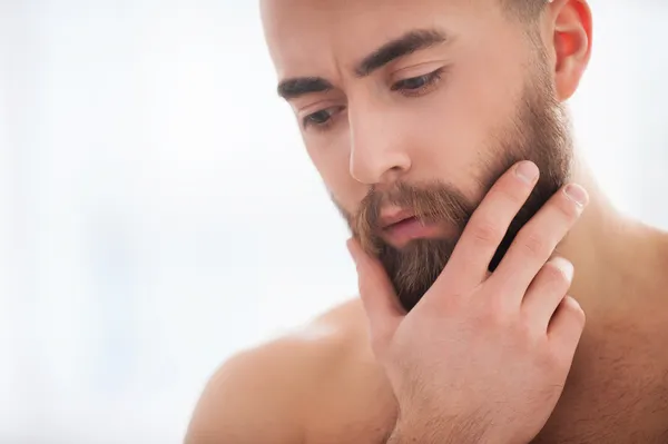 Jeune homme barbe tenant la main sur le menton — Photo