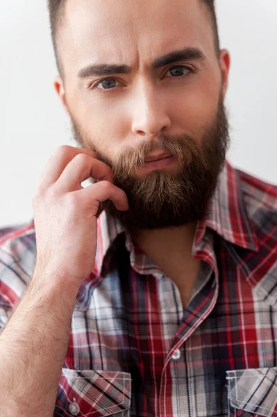 Close up of man in smart casual holding hand on beard — Stock Photo, Image