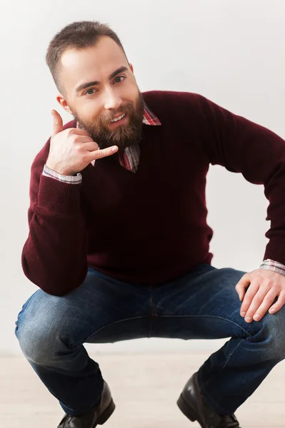 Hombre barbudo mostrando una señal de llamada y sonriendo — Foto de Stock