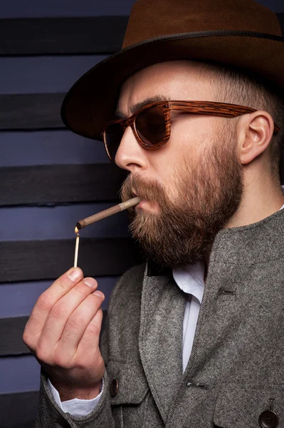 Man in sunglasses lights a cigarette — Stock Photo, Image