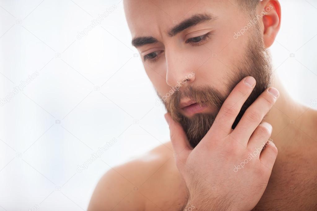 Young beard man holding hand on chin