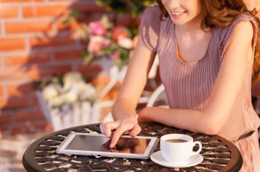 Cropped image of woman working on digital tablet clipart