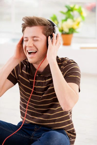 Homem em fones de ouvido ouvindo a música e mantendo os olhos fechados — Fotografia de Stock