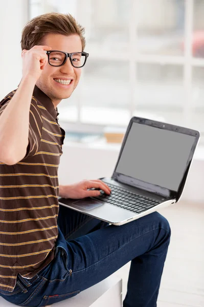 Homem trabalhando no laptop e olhando por cima do ombro — Fotografia de Stock