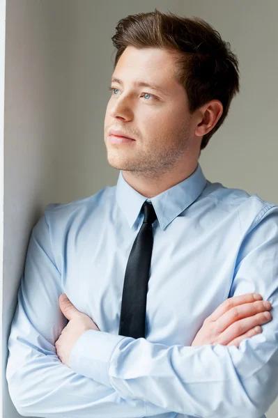 Hombre con camisa y corbata mirando hacia otro lado y manteniendo los brazos cruzados —  Fotos de Stock