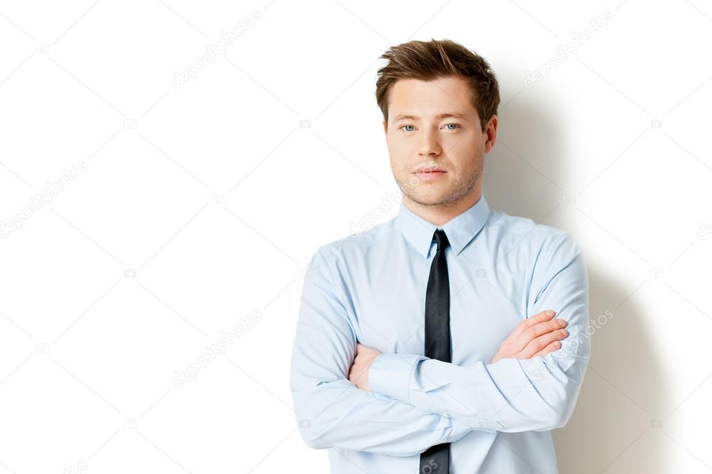 Man in formalwear looking at camera and keeping arms crossed