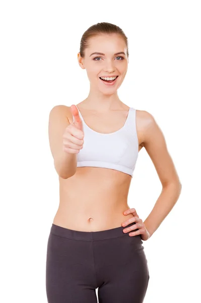 Woman in sports clothing showing her thumb up and smiling — Stock Photo, Image