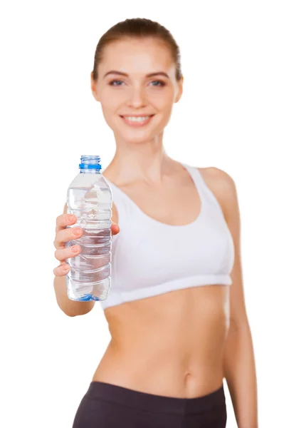 Mujer con ropa deportiva sosteniendo una botella con agua y sonriendo — Foto de Stock