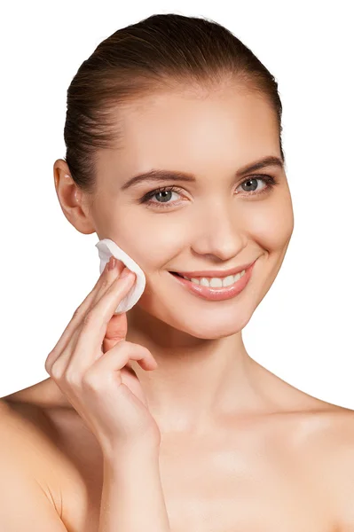 Mujer limpiándose la cara con esponja y sonriendo —  Fotos de Stock