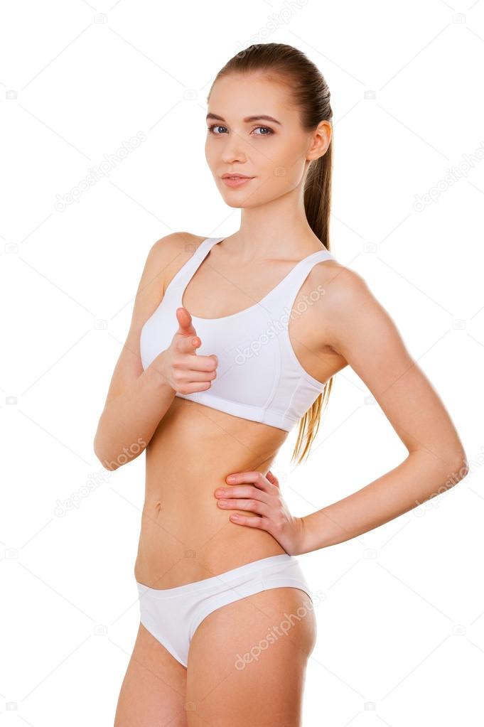 Woman in white bra and panties holding one hand on hip and