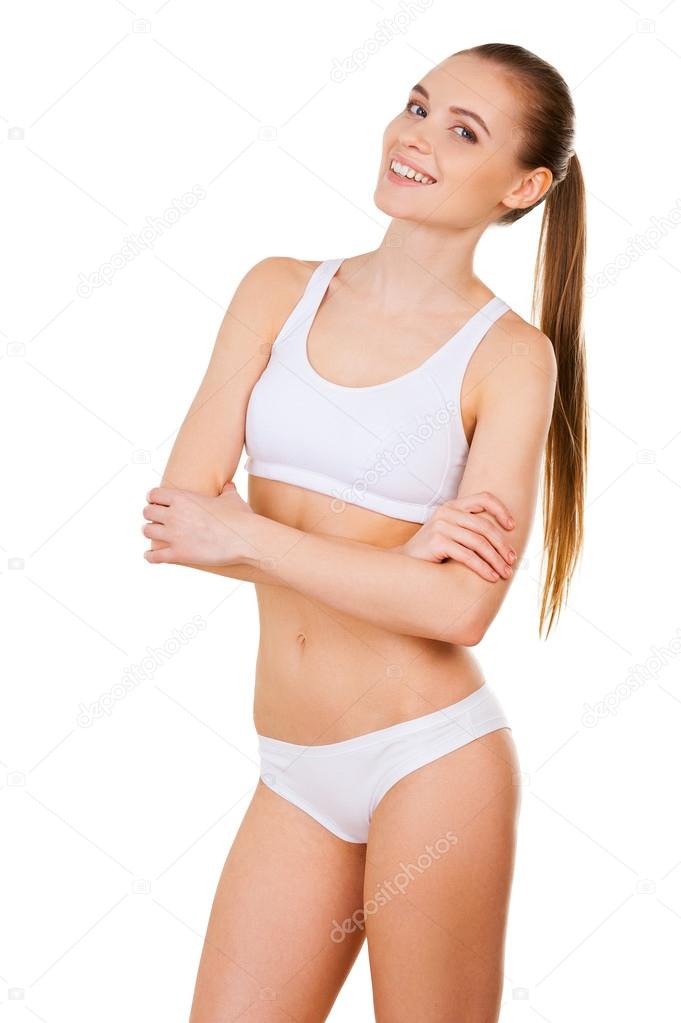 Woman in white bra and panties keeping arms crossed and looking at camera