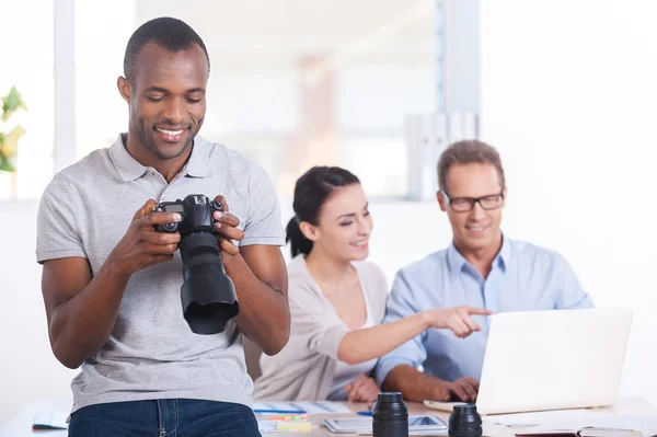 African man holding camera and smiling — Stock Photo, Image