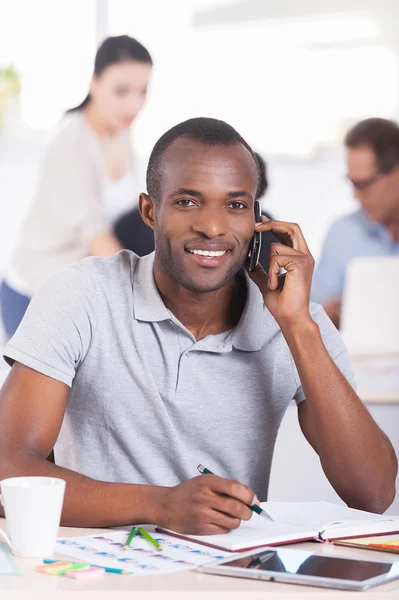 Afrikaanse man praten op de mobiele telefoon en glimlachen — Stockfoto