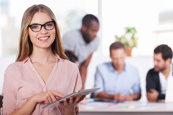 Mujer en gafas trabajando en tableta digital y sonriendo — Foto de Stock