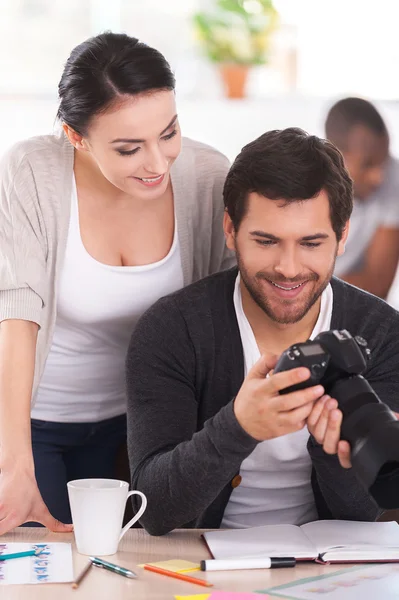 Two co-workers discussing something while man holding camera — Stock Photo, Image
